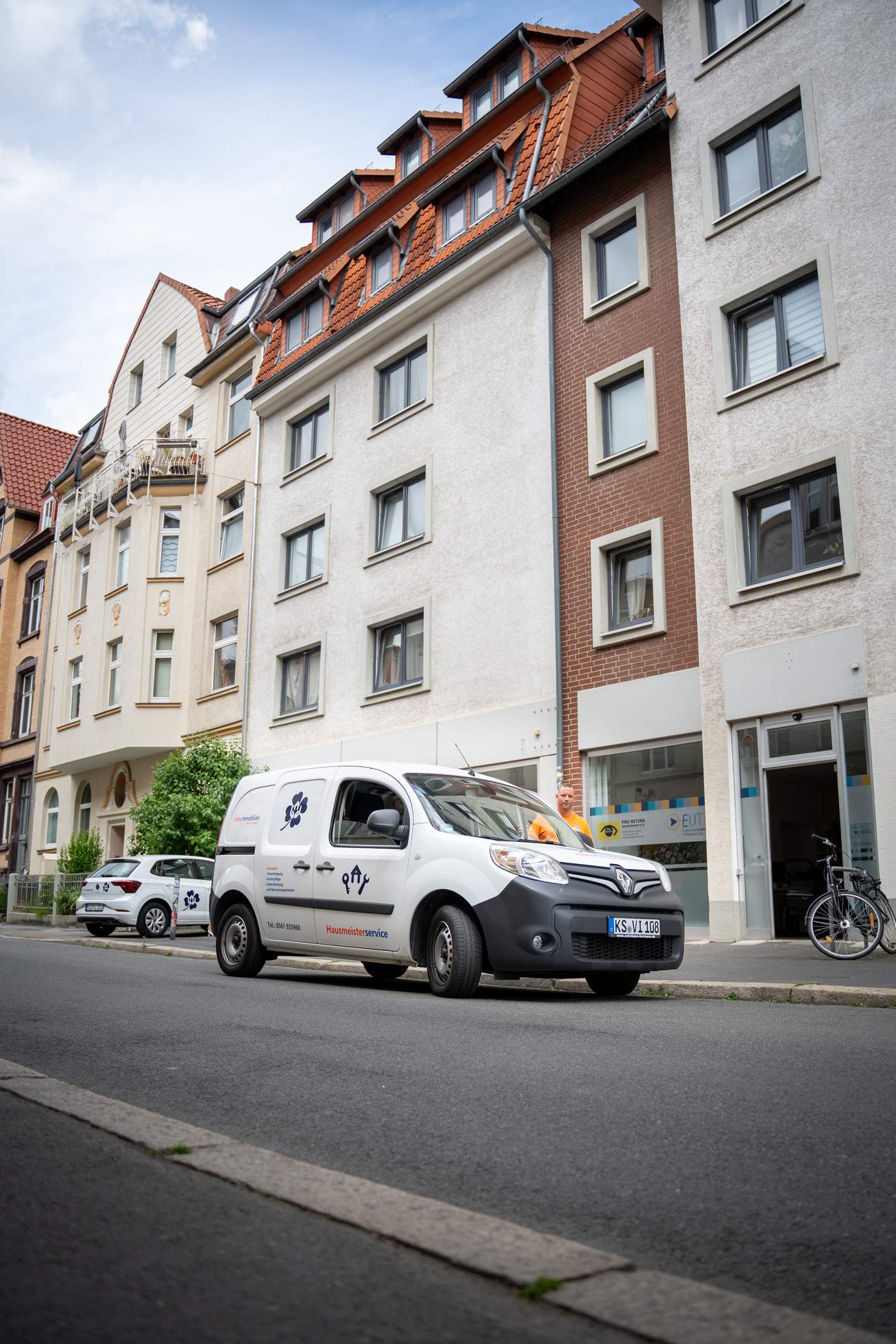 Servicefahrzeug für Hausreinigung, Gartenpflege und Instandsetzung vor einer Wohnimmobilie – Hausmeisterservice von Volksbank Immobilien Kassel Göttingen