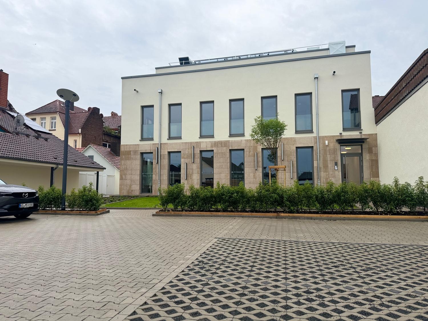 Moderne Rückansicht eines Geschäftsgebäudes mit gepflegtem Vorplatz, Hecken und Parkplatz - Verwaltung im Rahmen von professionellem Property Management