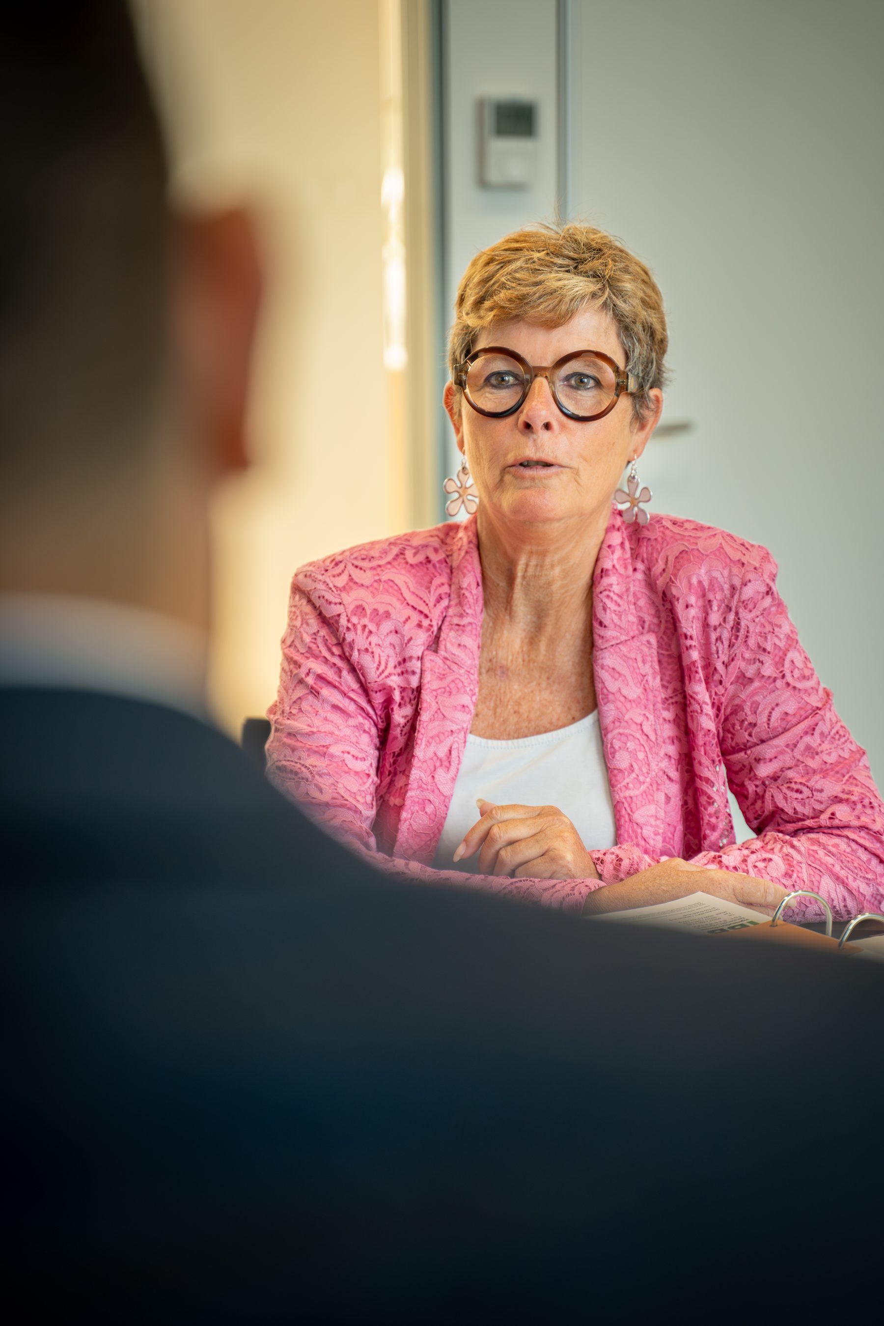 Mitarbeiterin am Tisch sitzend bei einem juristischen Gespräch – Teil der juristischen Prüfung der professionellen Hausverwaltung