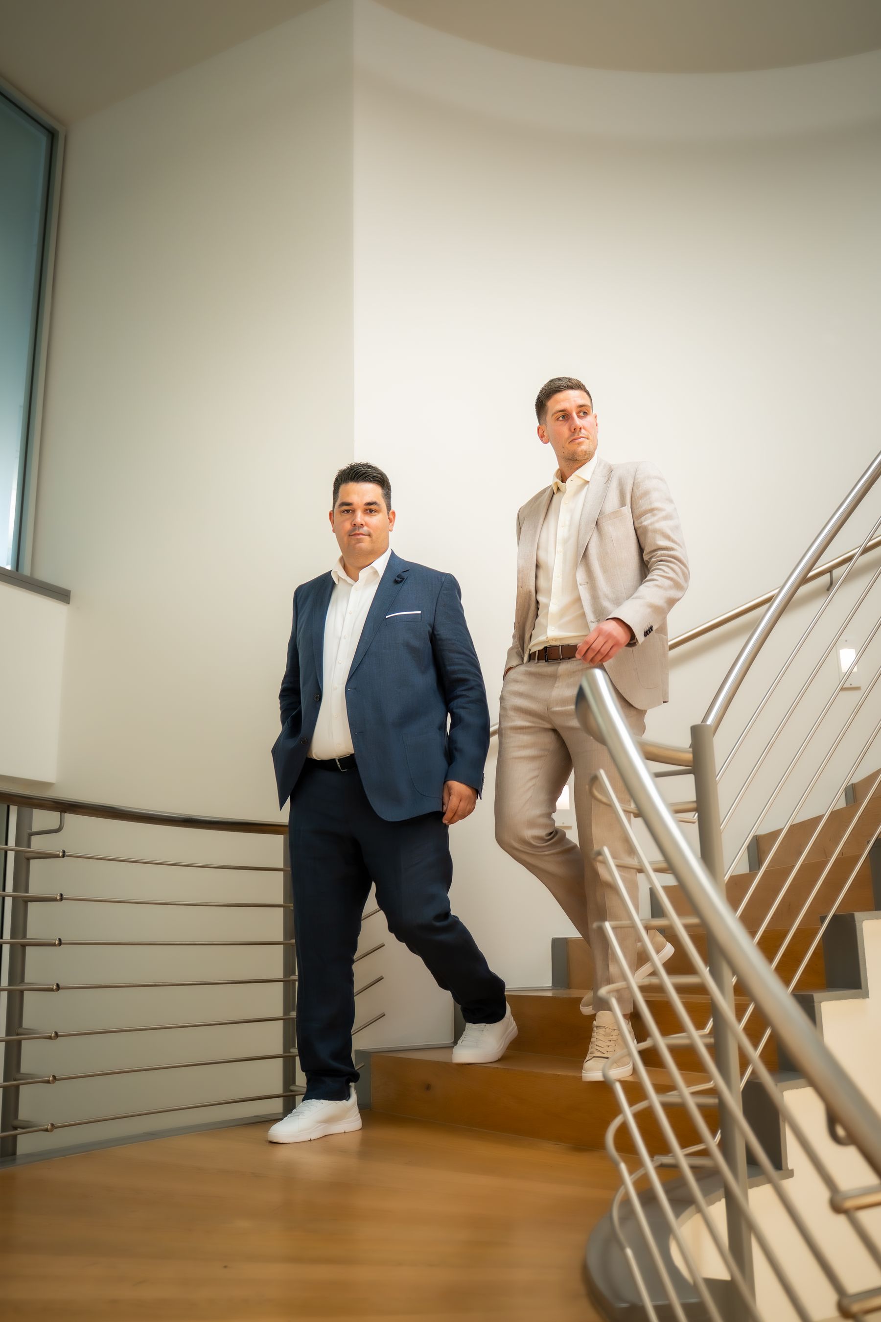 Zwei Mitarbeiter gehen gemeinsam eine Treppe im Bürogebäude hinunter 