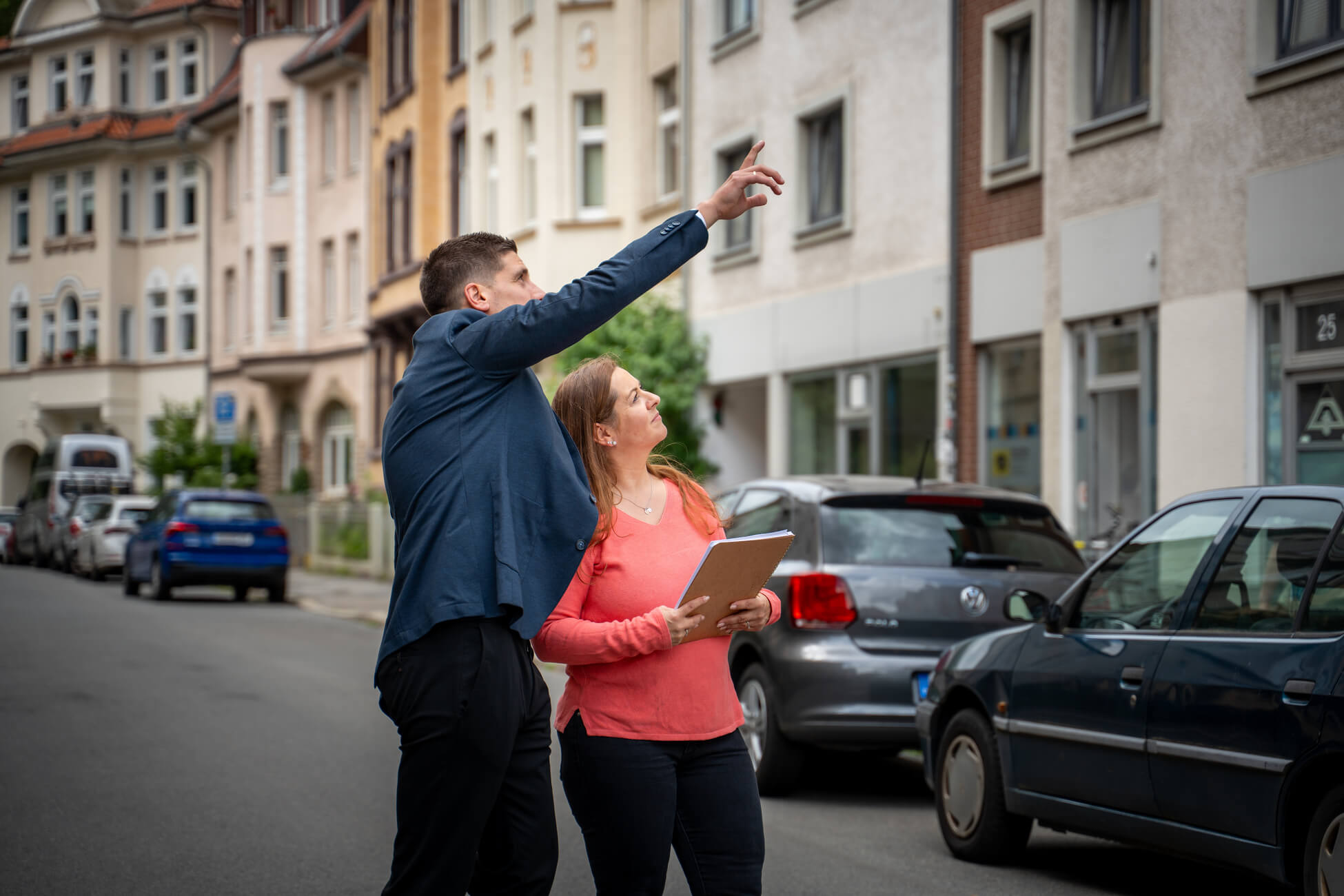 Zwei Personen besichtigen gemeinsam eine Immobilie und begutachten die Fassade eines Altbaus – Volksbank Immobilien GmbH Kassel Göttingen im Rahmen der eigenen WEG-Verwaltung 