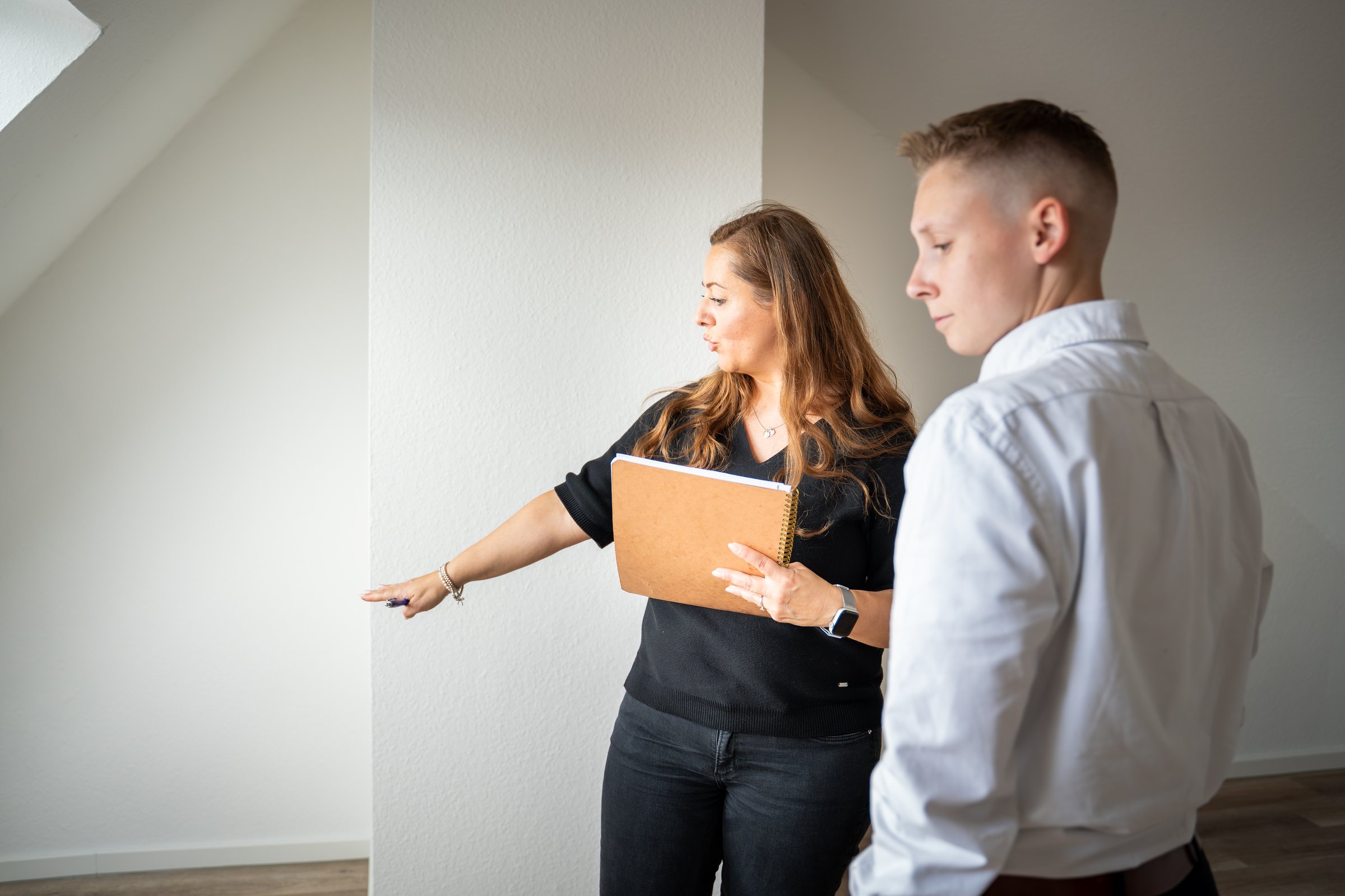 Zwei Verwaltungsexperten begutachten gemeinsam eine leerstehende Dachgeschosswohnung als Sondereigentum – SEV Verwaltung von Volksbank Immobilien Kassel Göttingen