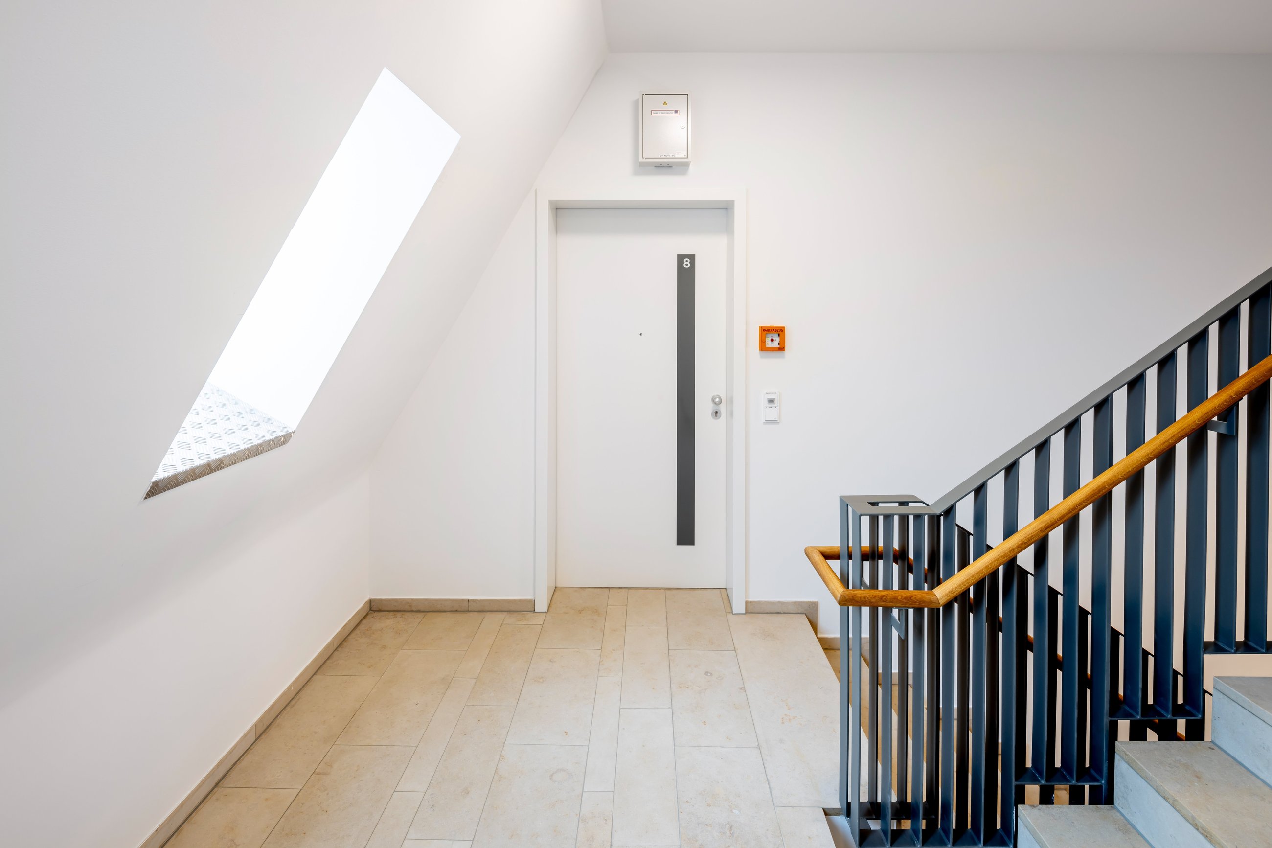 Helles Treppenhaus mit Brandschutzeinrichtungen und Wohnungseingangstür im Rahmen der WEG-Verwaltung von Voba Immobilien Kassel Göttingen